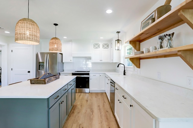 kitchen featuring pendant lighting, sink, appliances with stainless steel finishes, tasteful backsplash, and white cabinetry