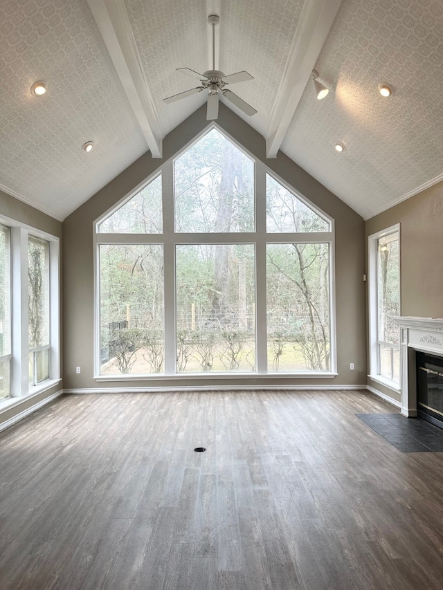 unfurnished living room with dark hardwood / wood-style floors, ceiling fan, and lofted ceiling with beams