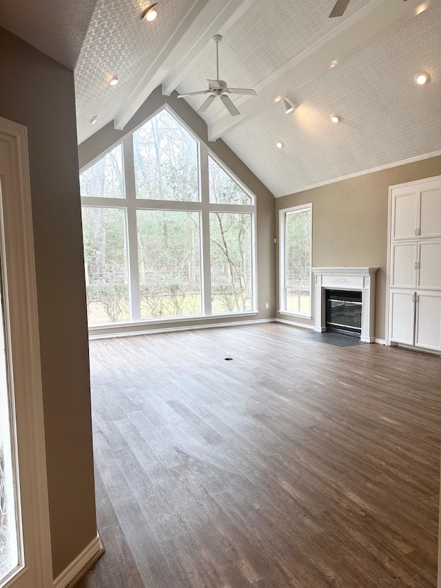 unfurnished living room with lofted ceiling with beams, dark hardwood / wood-style flooring, and ceiling fan