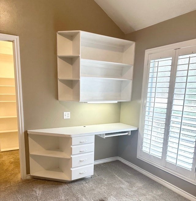 interior space with carpet, built in desk, and lofted ceiling