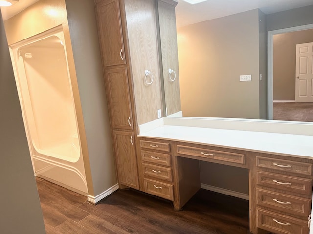 bathroom with wood-type flooring, washtub / shower combination, and vanity