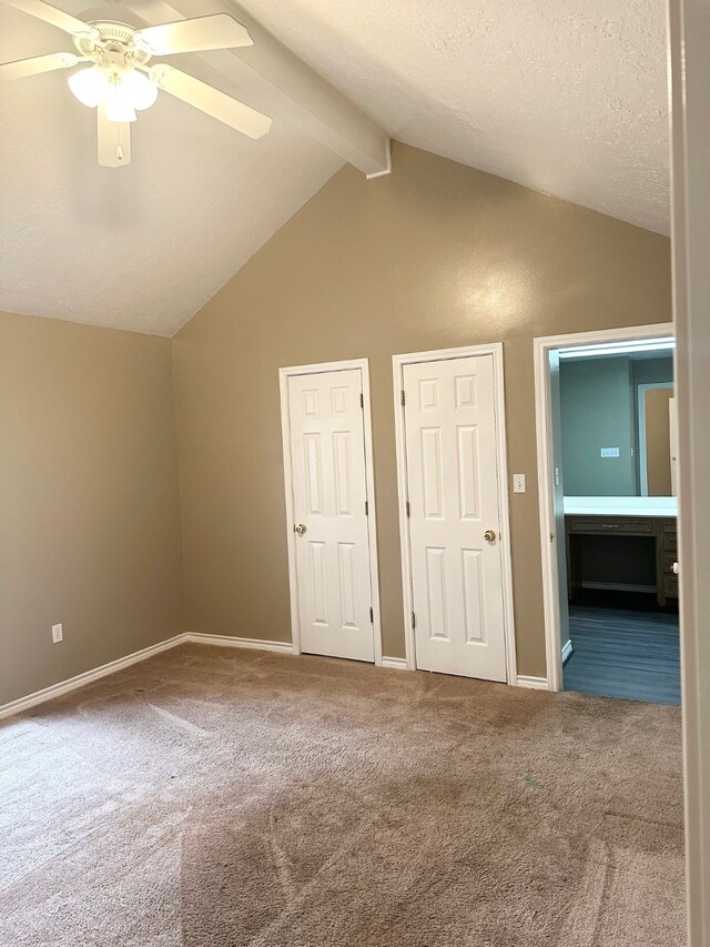 additional living space featuring dark carpet, ceiling fan, and lofted ceiling with beams