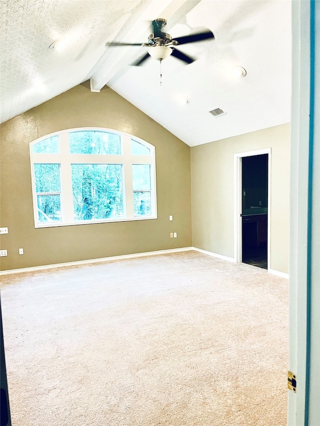 empty room with vaulted ceiling with beams, ceiling fan, and carpet floors