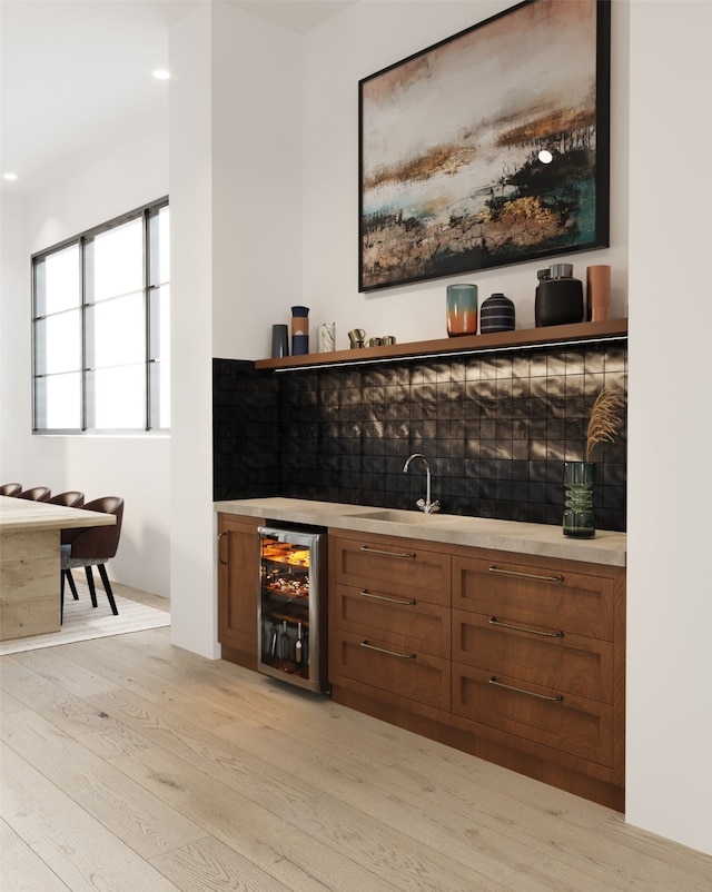 bar with wine cooler, sink, and light hardwood / wood-style floors