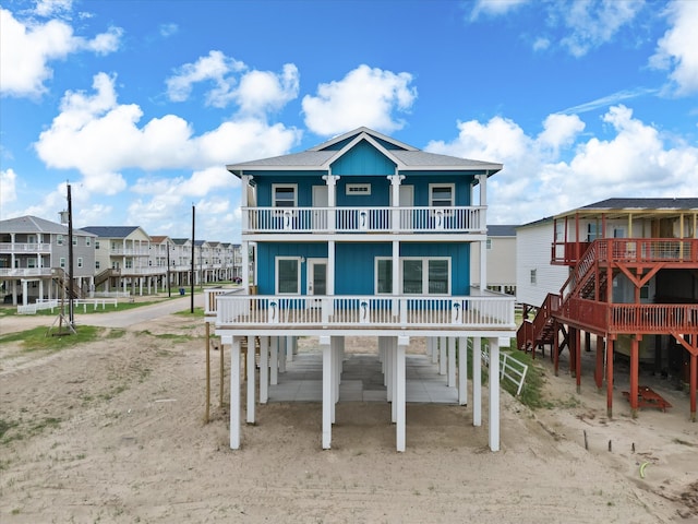 back of property featuring a balcony and a carport