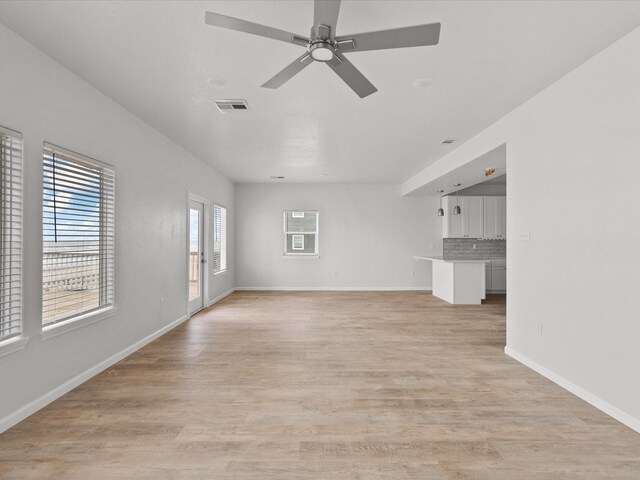 unfurnished living room with light wood-type flooring and ceiling fan