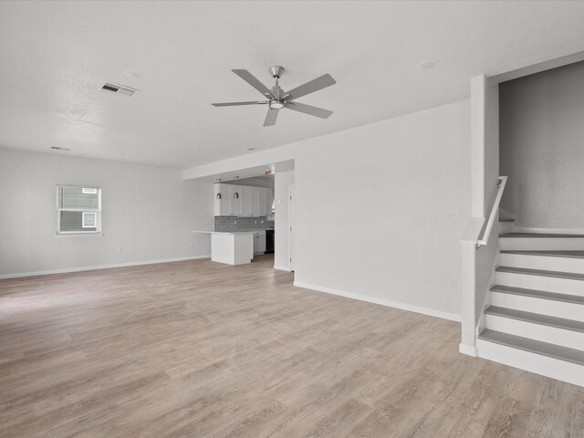 unfurnished living room with ceiling fan and light hardwood / wood-style floors