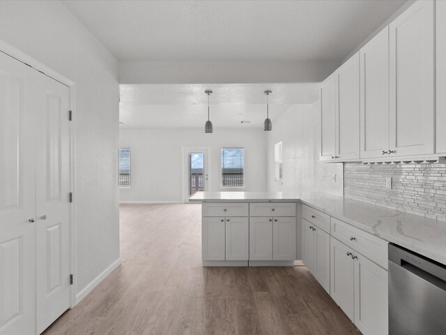 kitchen with dishwasher, hardwood / wood-style flooring, decorative backsplash, and kitchen peninsula