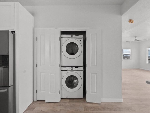 laundry area featuring light hardwood / wood-style flooring, ceiling fan, and stacked washer / dryer