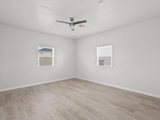 empty room featuring a textured ceiling, ceiling fan, and light hardwood / wood-style floors