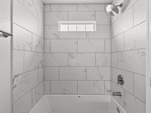 bathroom featuring tiled shower / bath