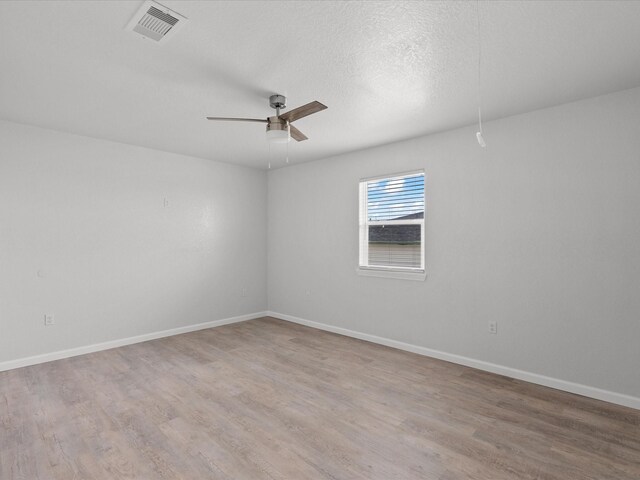 spare room featuring ceiling fan, wood-type flooring, and a textured ceiling