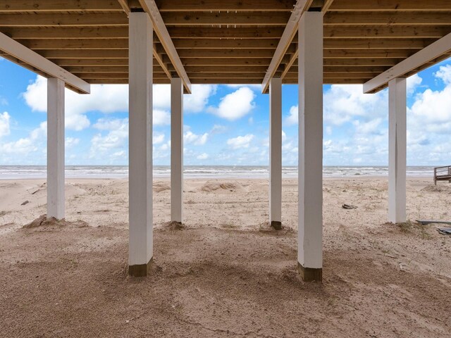 view of patio / terrace with a beach view and a water view