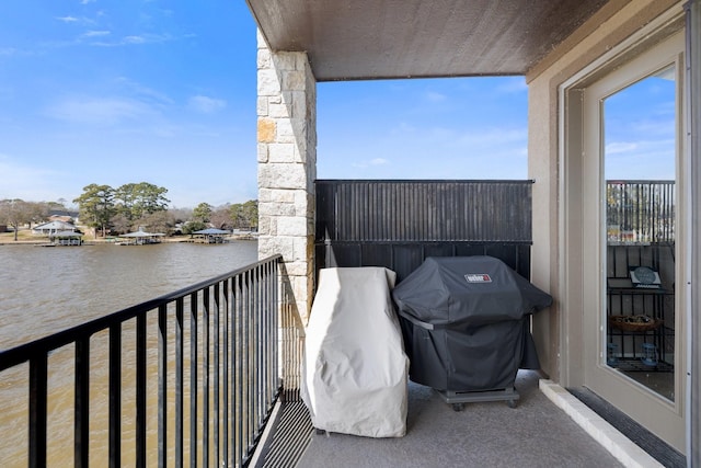 balcony with a water view and area for grilling