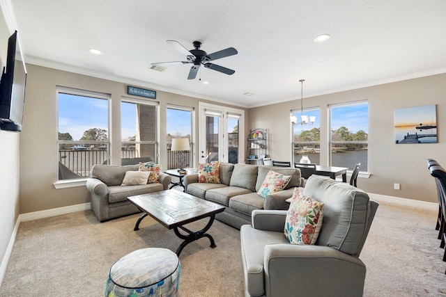 carpeted living room featuring crown molding, ceiling fan with notable chandelier, a healthy amount of sunlight, and a water view