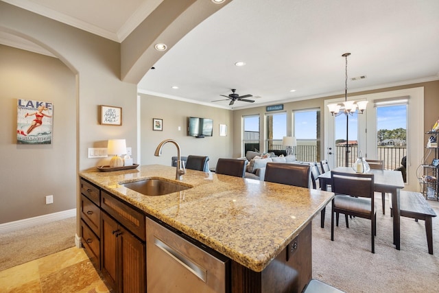 kitchen with sink, decorative light fixtures, stainless steel dishwasher, an island with sink, and light stone countertops