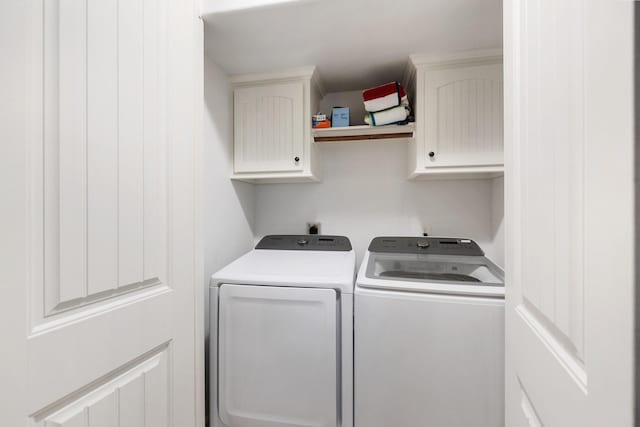 washroom with cabinets and washing machine and dryer