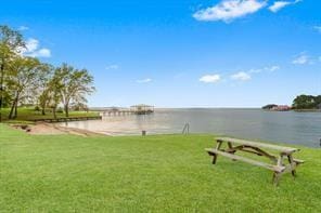 view of community featuring a lawn and a water view