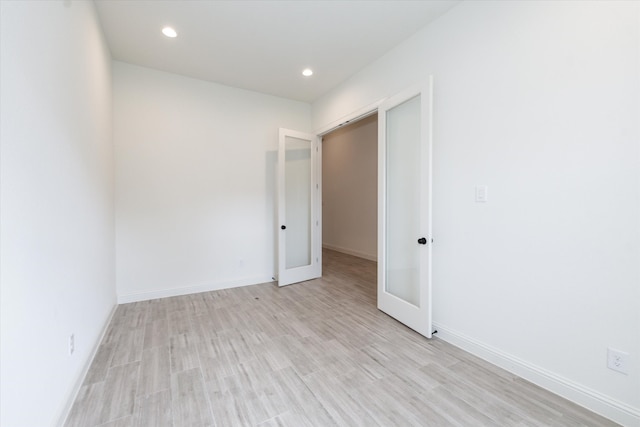 empty room featuring light hardwood / wood-style floors and french doors