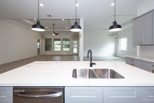 kitchen with stainless steel dishwasher, hanging light fixtures, gray cabinets, and a wealth of natural light