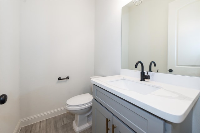 bathroom featuring vanity, toilet, and hardwood / wood-style flooring