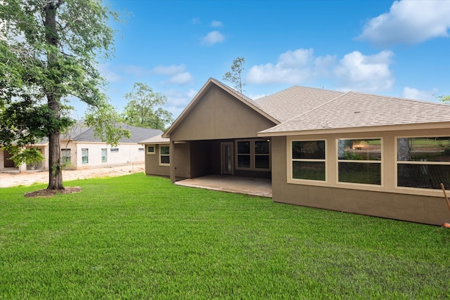 back of property with a yard and a patio area