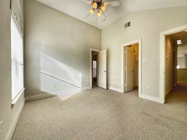 unfurnished bedroom featuring light colored carpet, vaulted ceiling, and ceiling fan