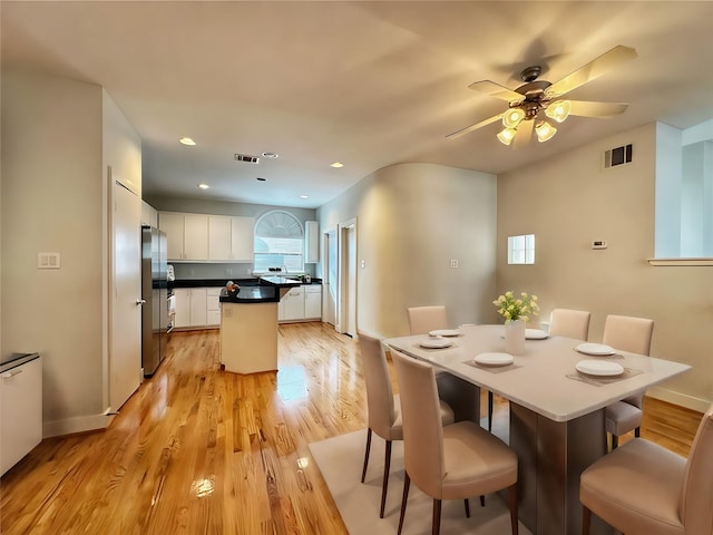 dining area with light hardwood / wood-style floors and ceiling fan