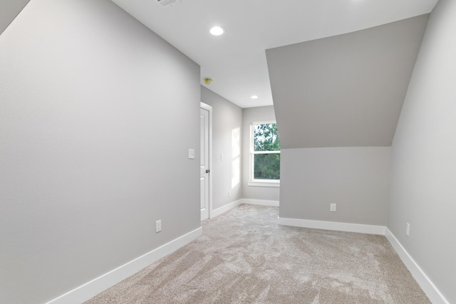 bonus room featuring lofted ceiling and light colored carpet