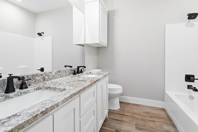 full bathroom with double sink vanity, bathing tub / shower combination, toilet, and hardwood / wood-style flooring