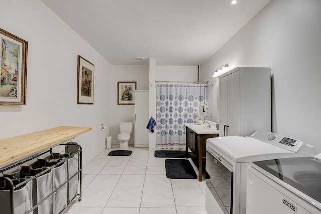 laundry room featuring washer and clothes dryer and light tile patterned floors