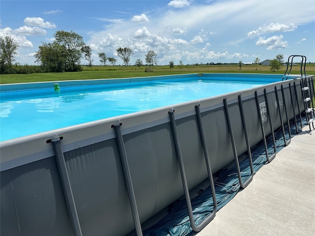 view of swimming pool with a lawn