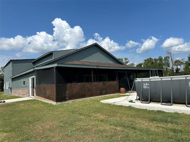 view of home's exterior with a yard and a sunroom