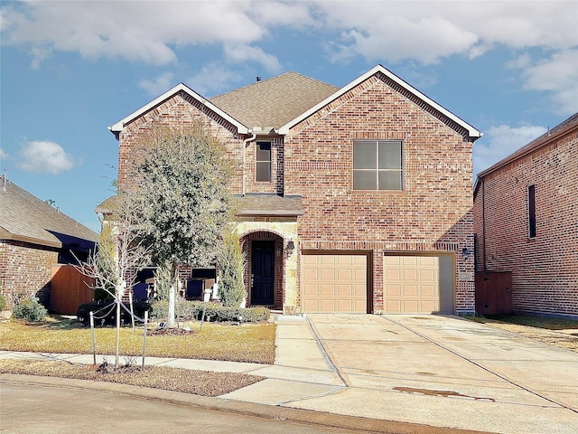 traditional-style house with concrete driveway, brick siding, an attached garage, and a shingled roof