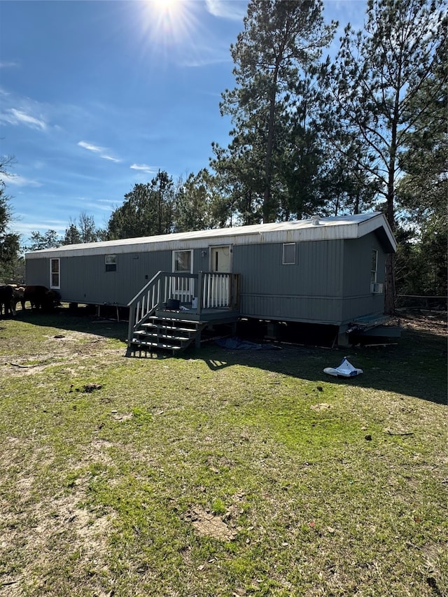 back of property with a yard and a deck