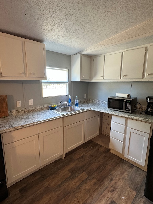 kitchen with sink, white cabinetry, a textured ceiling, and dark hardwood / wood-style flooring