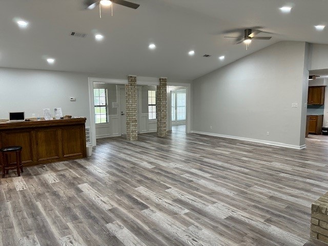 living room with ceiling fan, vaulted ceiling, hardwood / wood-style floors, and decorative columns