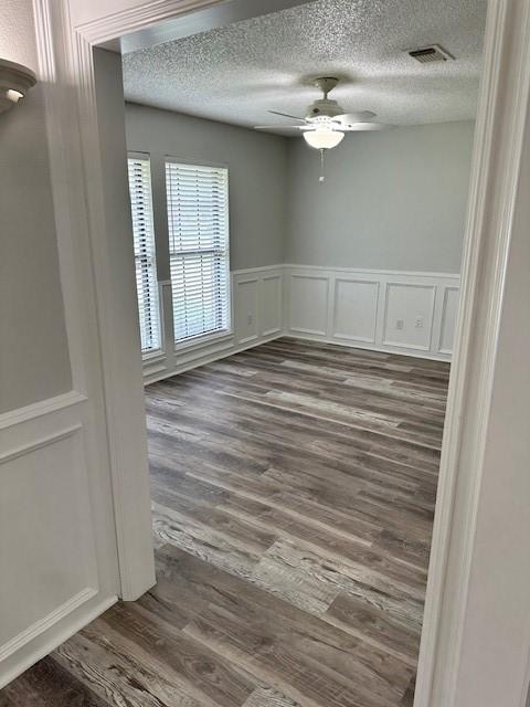 spare room featuring ceiling fan, a textured ceiling, and dark hardwood / wood-style flooring