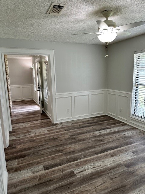 empty room featuring ceiling fan, dark hardwood / wood-style floors, and a textured ceiling