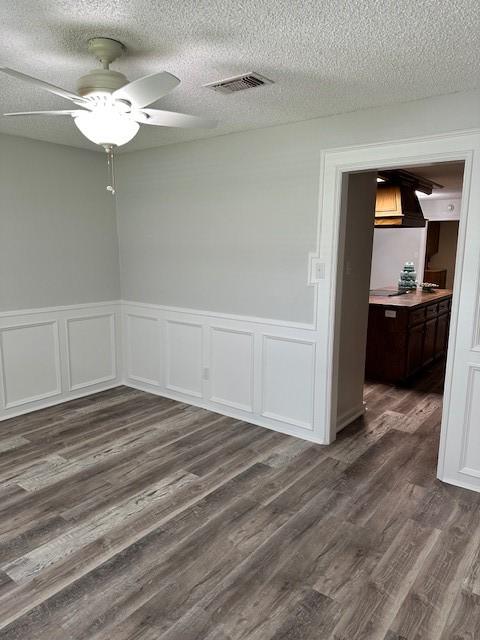 spare room featuring ceiling fan, a textured ceiling, and dark wood-type flooring