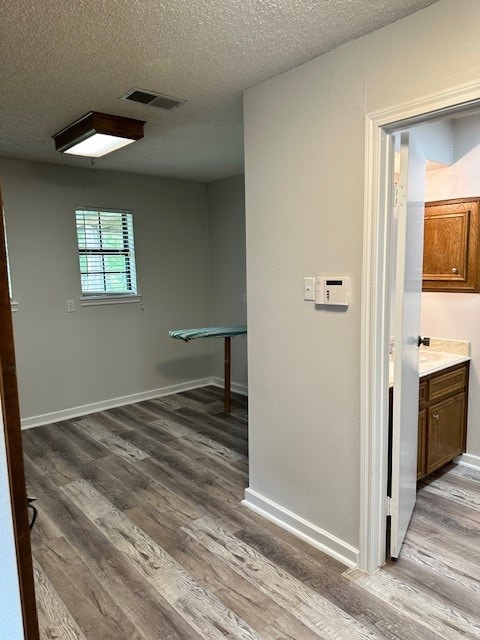 hall featuring a textured ceiling and dark hardwood / wood-style floors