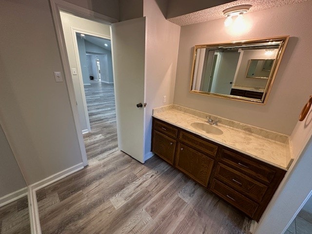 bathroom featuring a textured ceiling, wood-type flooring, and vanity