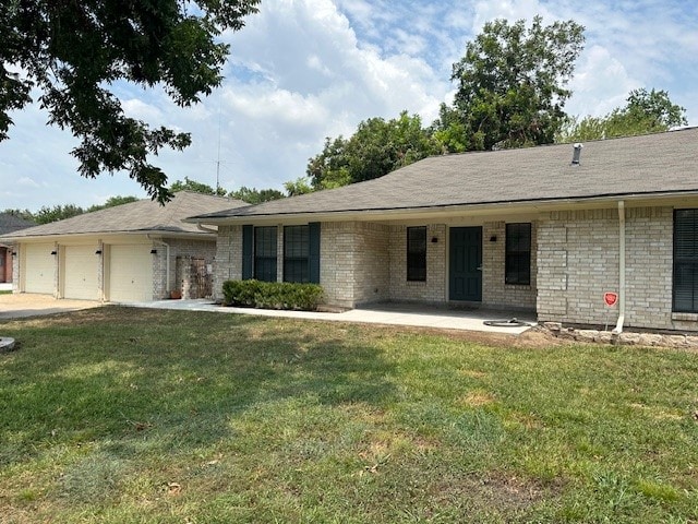 ranch-style home featuring a garage and a front lawn