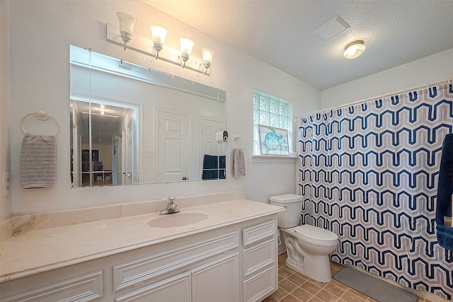 bathroom with toilet, a textured ceiling, vanity, and tile flooring