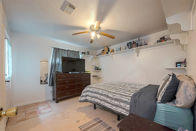 bedroom with ceiling fan and a textured ceiling