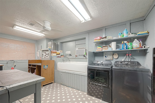 clothes washing area featuring a textured ceiling, water heater, ceiling fan, and independent washer and dryer