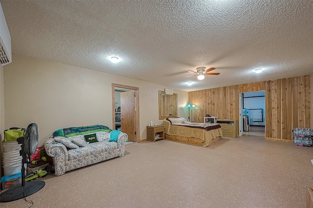 bedroom featuring ceiling fan, a textured ceiling, and wooden walls