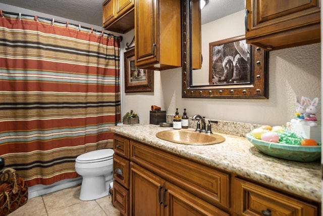 bathroom featuring toilet, a textured ceiling, large vanity, and tile flooring