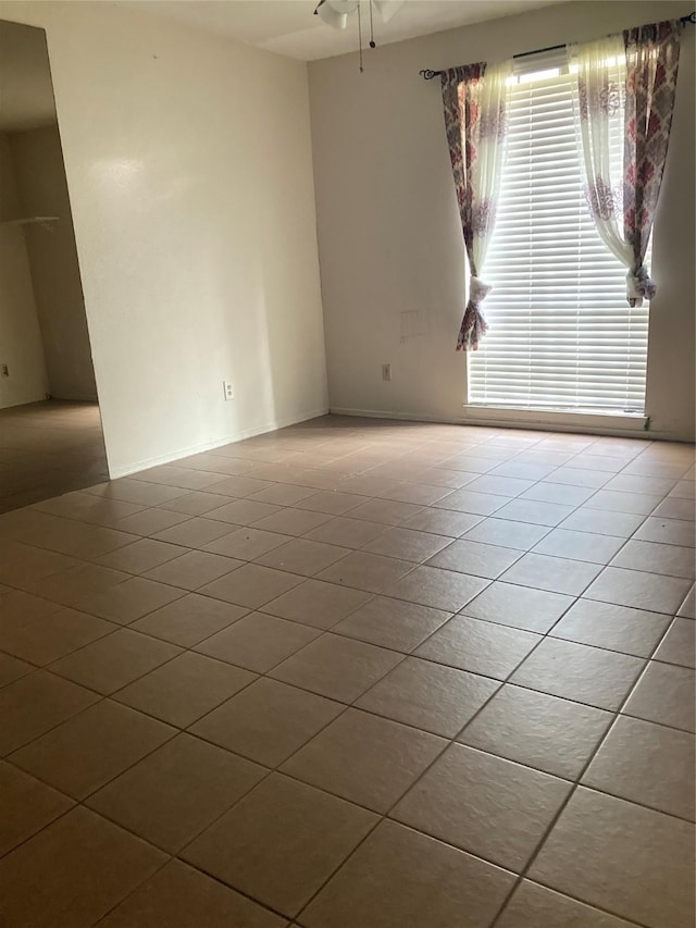 spare room featuring ceiling fan and light tile patterned floors