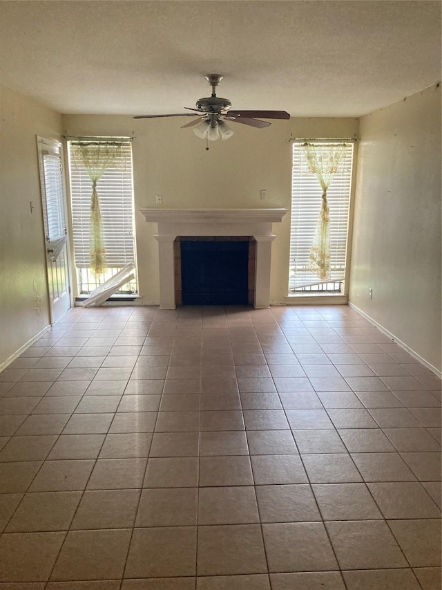 unfurnished living room with tile patterned flooring, a textured ceiling, and ceiling fan